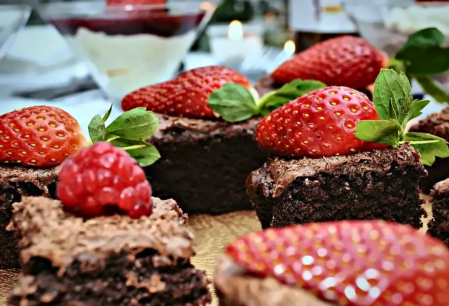 Chocolate brownies topped with strawberries and mint